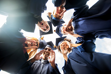 Image showing happy students or bachelors in mortar boards