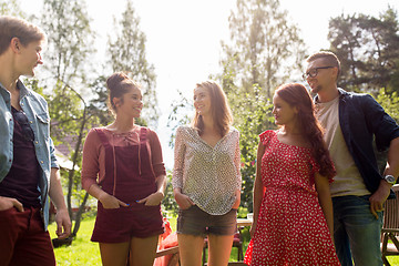 Image showing happy teenage friends talking at summer garden