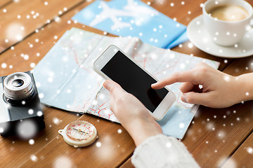 Image showing close up of traveler hands with smartphone and map