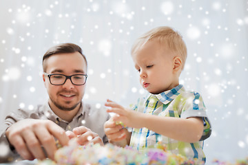 Image showing father and son playing with ball clay at home