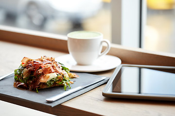 Image showing prosciutto ham salad with tablet pc at restaurant