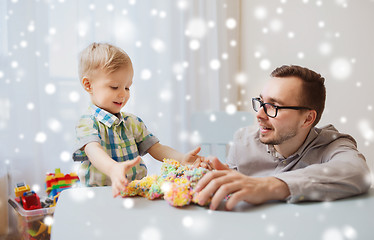 Image showing father and son playing with ball clay at home