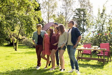 Image showing happy teenage friends talking at summer garden