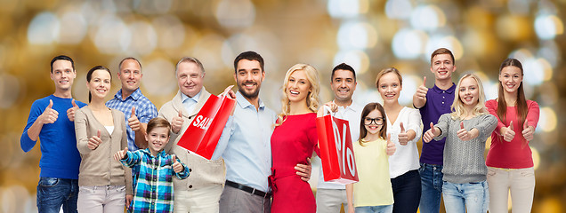 Image showing happy people with shopping bags showing thumbs up