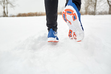 Image showing close up of feet running along snowy winter road