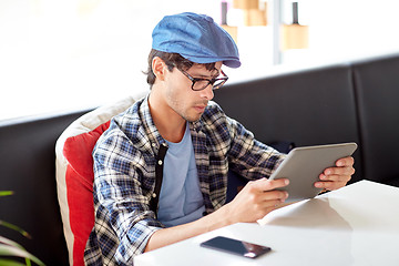 Image showing man with tablet pc sitting at cafe table