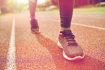 Image showing close up of woman feet running on track from back