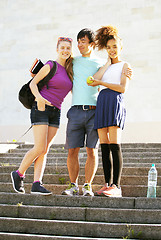 Image showing cute group of teenages at the building of university with books 