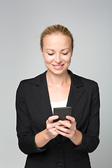Image showing Beautiful young caucasian businesswoman using mobile phone.