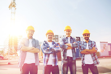 Image showing group of smiling builders in hardhats outdoors