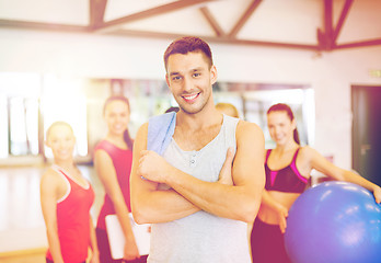 Image showing smiling man standing in front of the group in gym