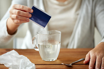 Image showing woman pouring medication into cup of water