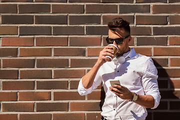 Image showing man with smartphone and coffee cup on city street