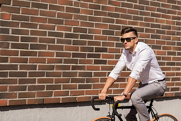 Image showing young man riding bicycle on city street