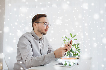 Image showing creative male office worker texting on smartphone