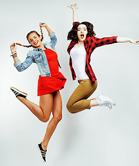 Image showing two pretty brunette and blonde teenage girl friends jumping happy smiling on white background, lifestyle people concept