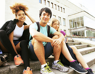 Image showing cute group of teenages at the building of university with books 