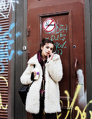 Image showing young pretty stylish teenage girl outside at city wall with graf