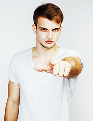 Image showing young handsome man on white background gesturing, pointing, posi