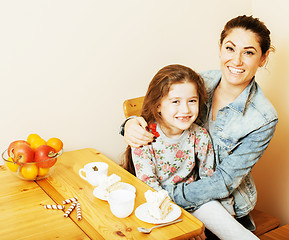 Image showing young mother with daughter on kitchen drinking tea together hugg