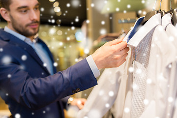 Image showing close up of man choosing shirt in clothing store