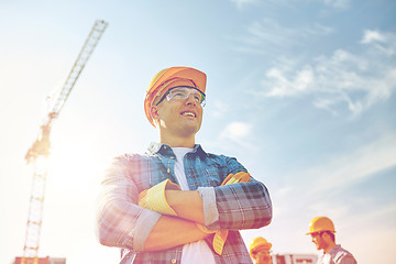 Image showing group of smiling builders in hardhats outdoors