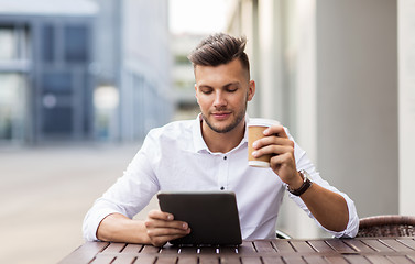 Image showing man with tablet pc and coffee at city cafe