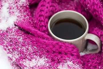 Image showing close up of tea or coffee and winter scarf in snow