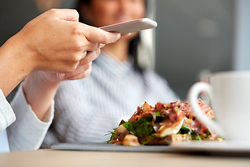 Image showing woman with smartphone and ham salad at restaurant