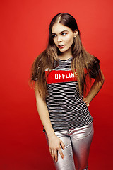 Image showing young pretty emitonal posing teenage girl on bright red background, happy smiling lifestyle people concept