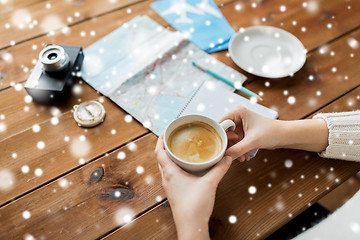 Image showing close up of hands with coffee cup and travel stuff