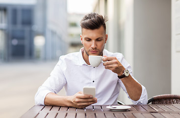 Image showing man with smartphone drinking coffee at city cafe