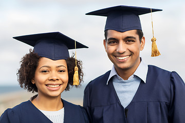 Image showing happy students or bachelors in mortar boards