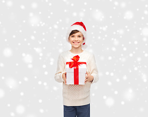 Image showing smiling happy boy in santa hat with gift box