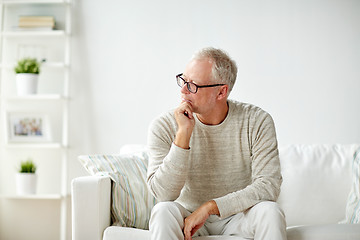 Image showing  senior man sitting on sofa at home and thinking