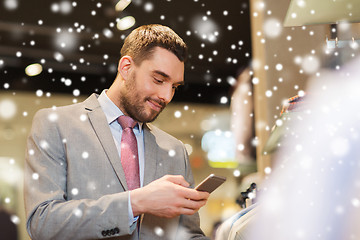 Image showing man in suit with smartphone at clothing store