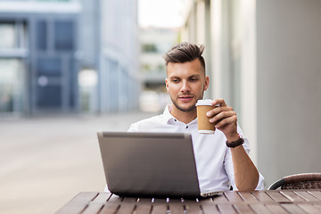 Image showing man with laptop and coffee at city cafe