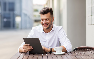 Image showing man with tablet pc and coffee at city cafe