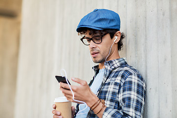 Image showing man with earphones and smartphone drinking coffee