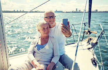 Image showing seniors with smartphone taking selfie on yacht