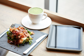 Image showing prosciutto ham salad with tablet pc at restaurant