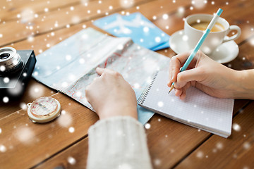 Image showing hands with map and coffee writing to notebook