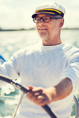 Image showing senior man at helm on boat or yacht sailing in sea