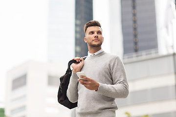 Image showing young man with smartphone and bag in city