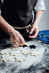 Image showing Person putting raw cookies to flour