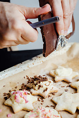 Image showing Cook decorating cookies with chocolate