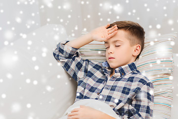 Image showing ill boy lying in bed and suffering from headache