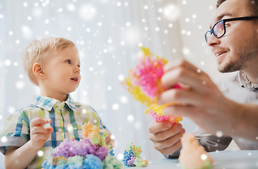 Image showing father and son playing with ball clay at home