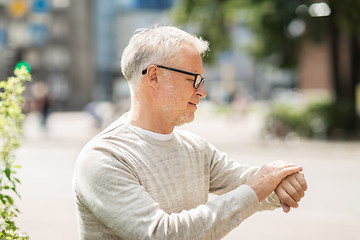 Image showing senior man checking time on his wristwatch