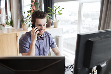 Image showing happy creative male worker calling on smarphone